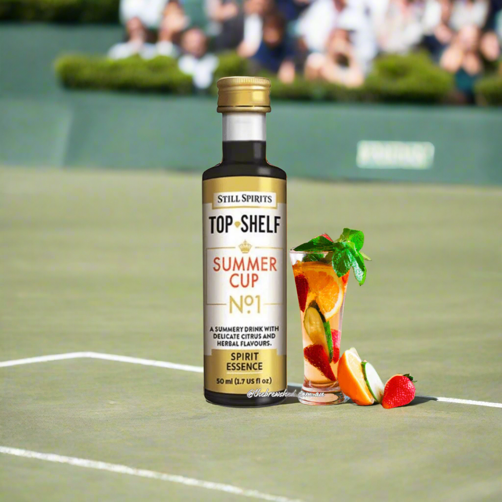 juicy cocktail in a tall glass served with ice, strawberry and mint, next to a lovely bottle of dark liquid