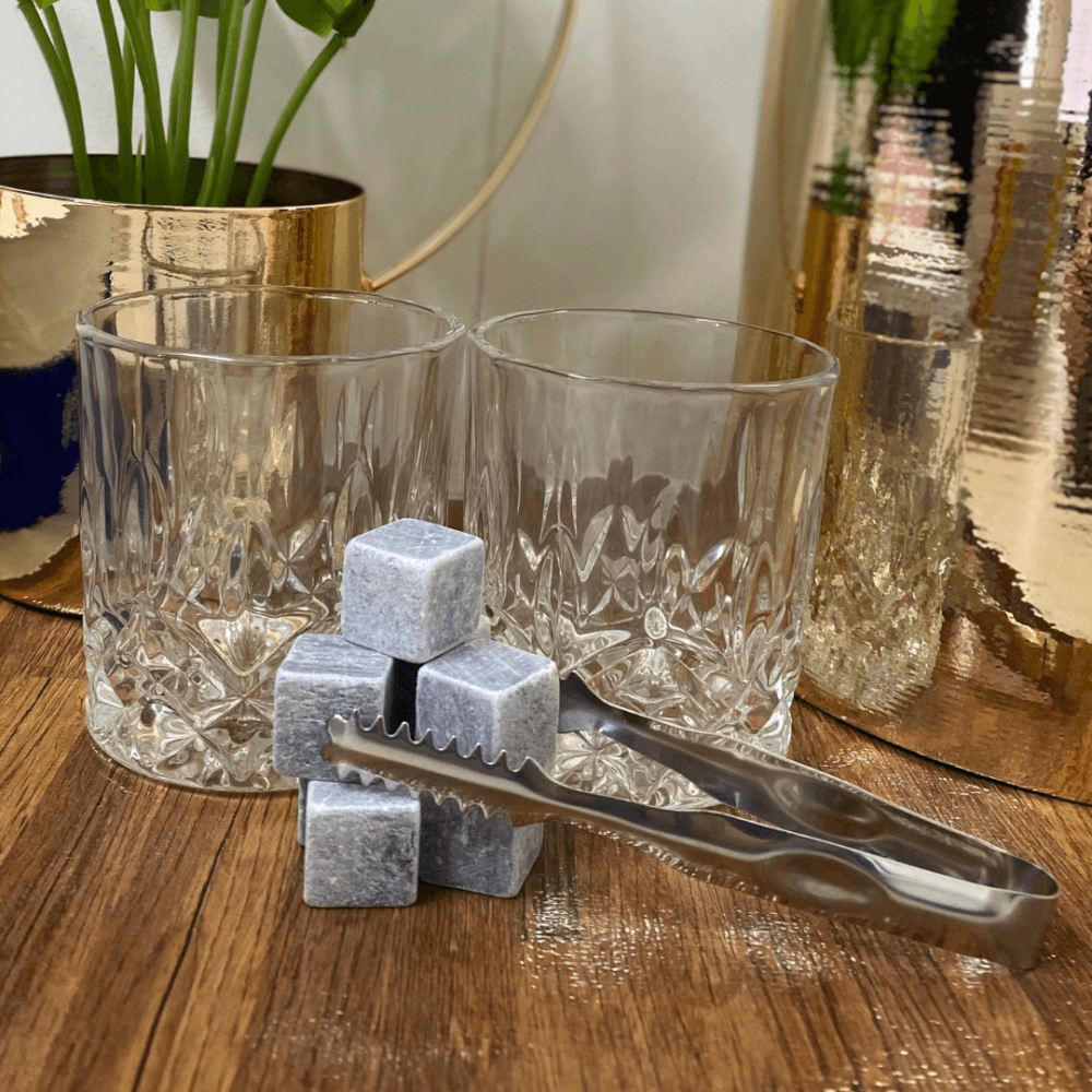 glass whiskey tumblers with rock cubes and ice tongs